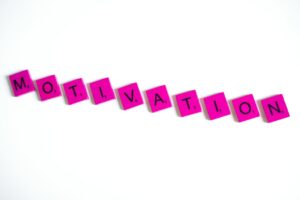 Pink letter tiles spelling 'motivation' on a white background.